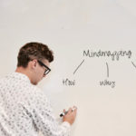 A man writing a simple mind map on mind mapping on a whiteboard